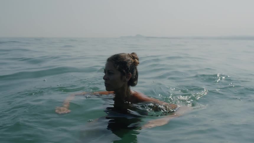 Woman swimming in neck deep water in the ocean