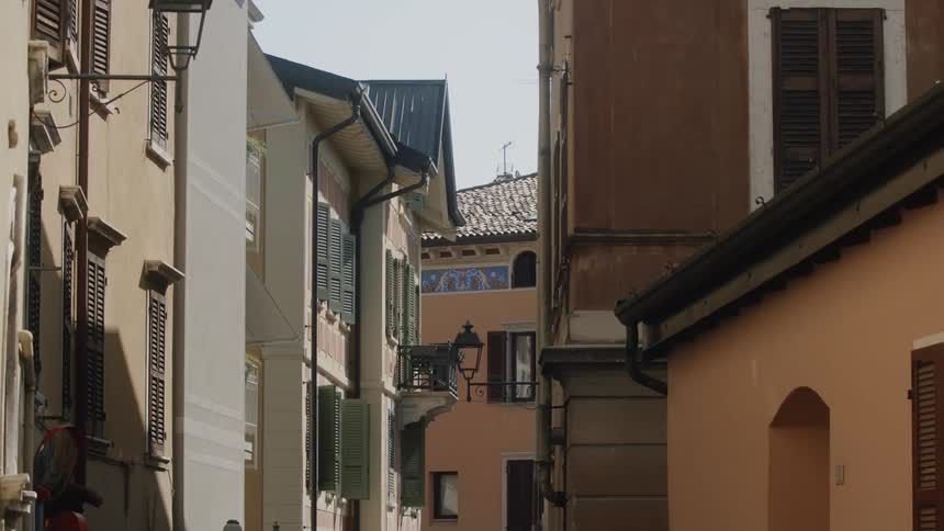 An alley runs through buildings of different colors that are very close together