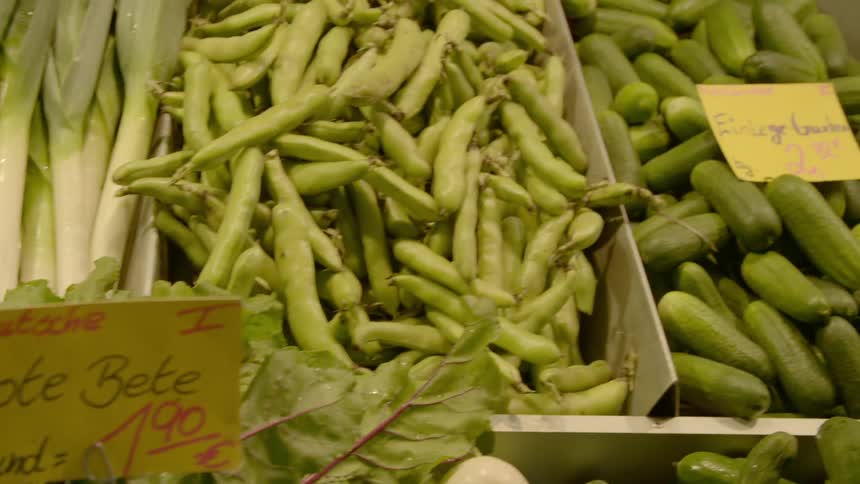 A variety of produce sorted into boxes and labeled with price tags