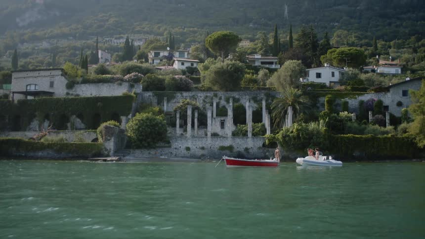People boating on a lake with a neighborhood in the background