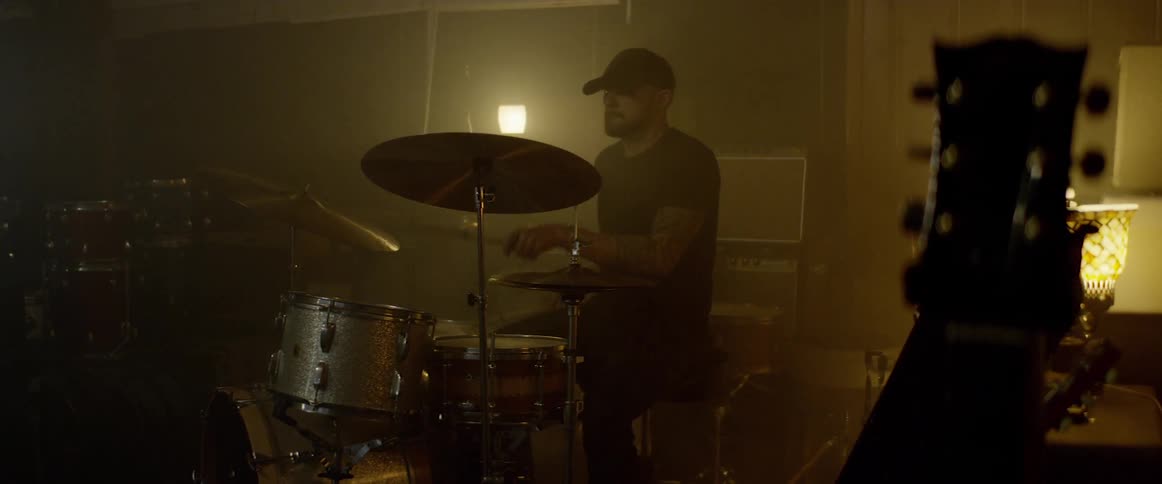 A person is playing drums indoors