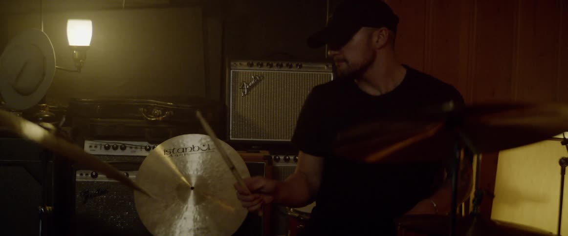 A young man plays the drums