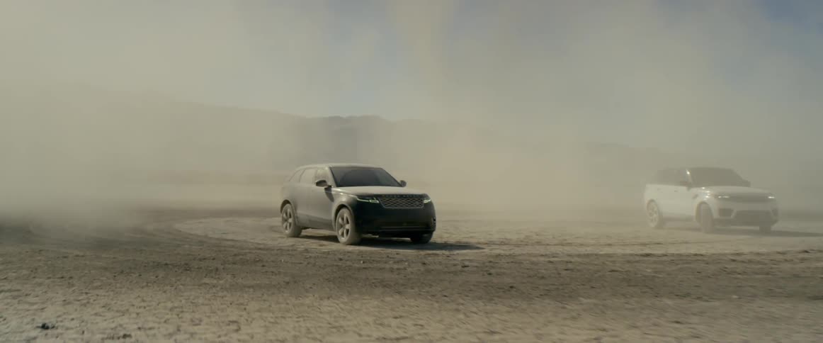 Two range rover sports parked on the salt flats in a cloud of dust and smoke
