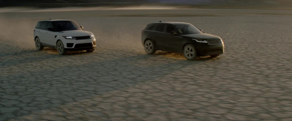 Two range rover sports come to a stop on the salt flats at sunset