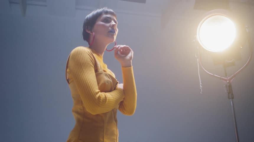 Woman modeling under the bright lights of a photo studio