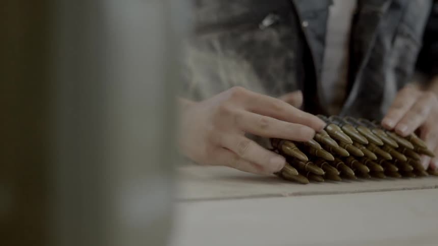 Man folds up a line of ammunition