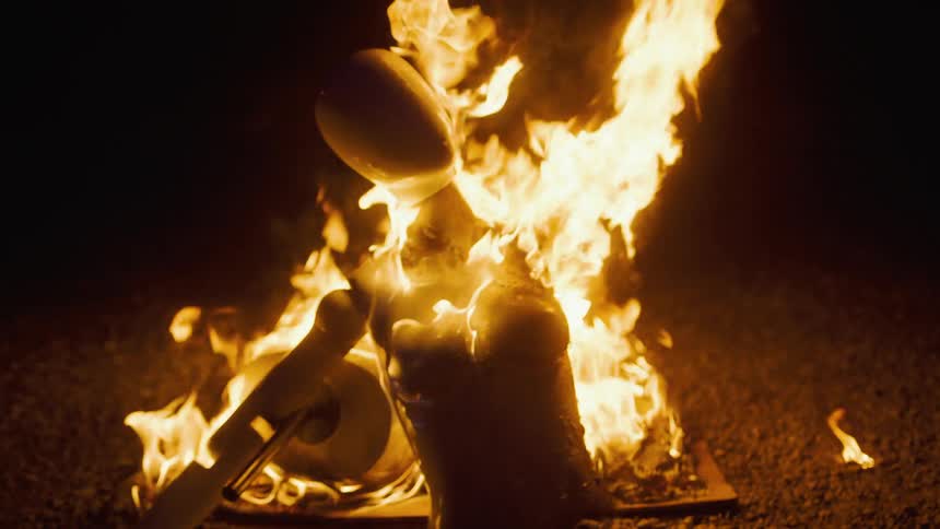 A wooden dummy burns in a fire
