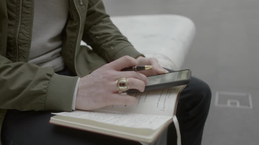 Man sitting on bench on passenger terminal checks smart phone
