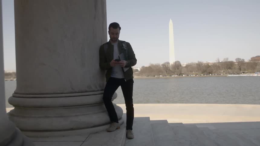 A man that is standing next to a pillar