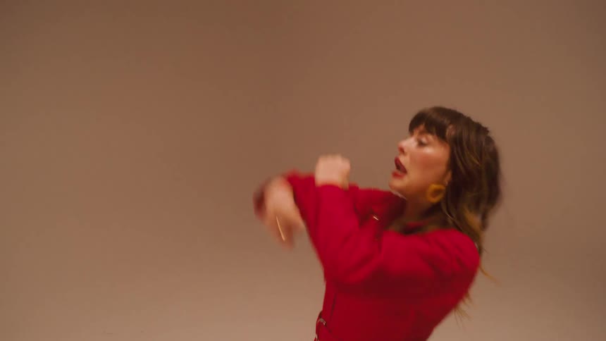 A young woman dances while making funny faces