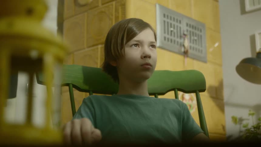 A teenage boy sits in a rocking chair
