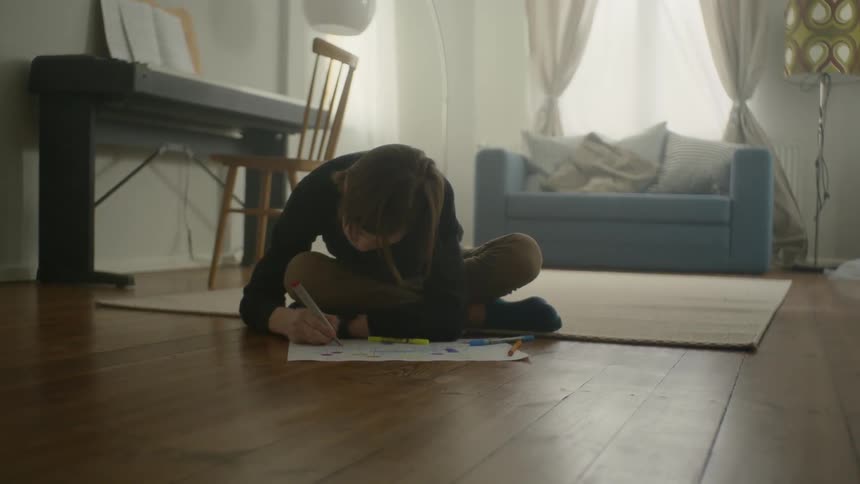 A child is drawing on the floor