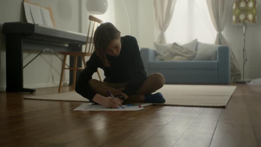 A person is drawing while sitting on the floor