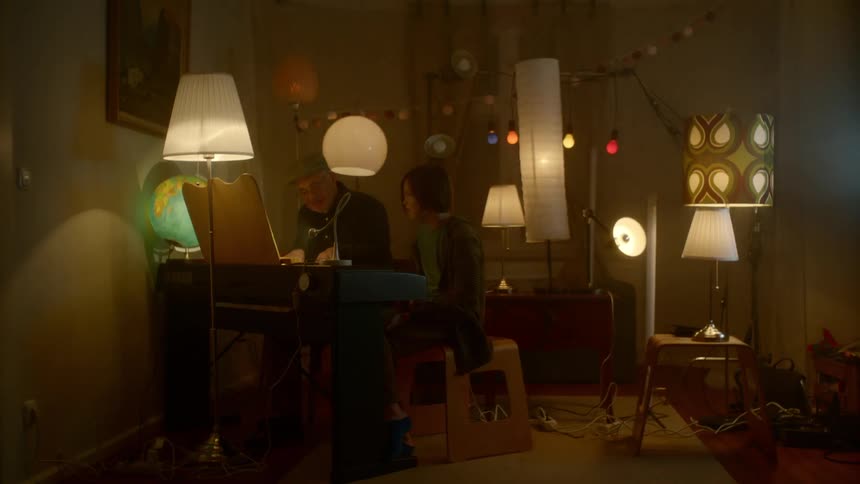 Two people playing piano in a room