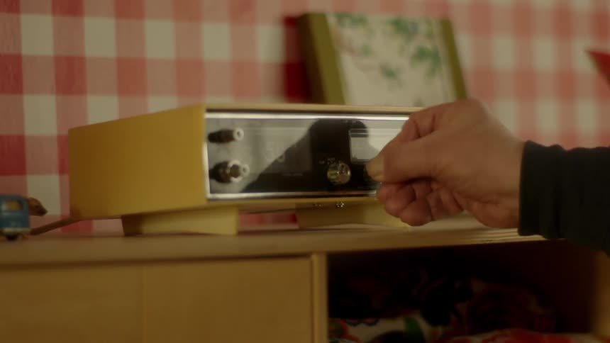 A man turns on a radio alarm clock