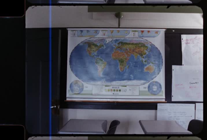 A vintage footage of a world map on classroom wall