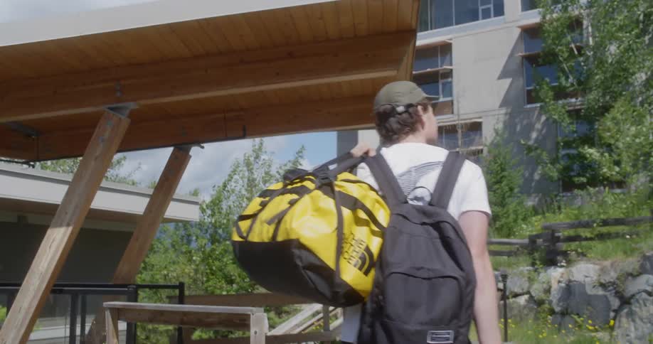 A man with yellow bag and luggage travelling alone