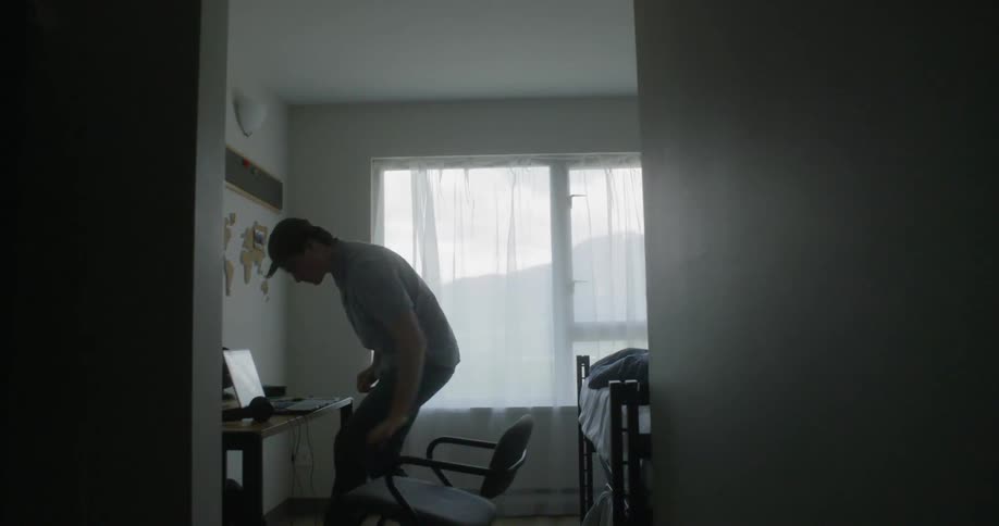 A man sitting down at a desk then typing on a laptop