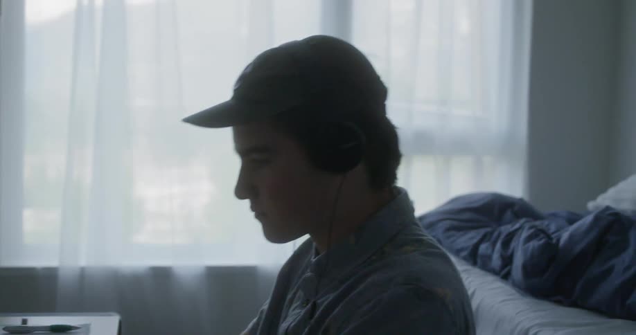 Man sitting at the table wears headphone and shakes his head in the room
