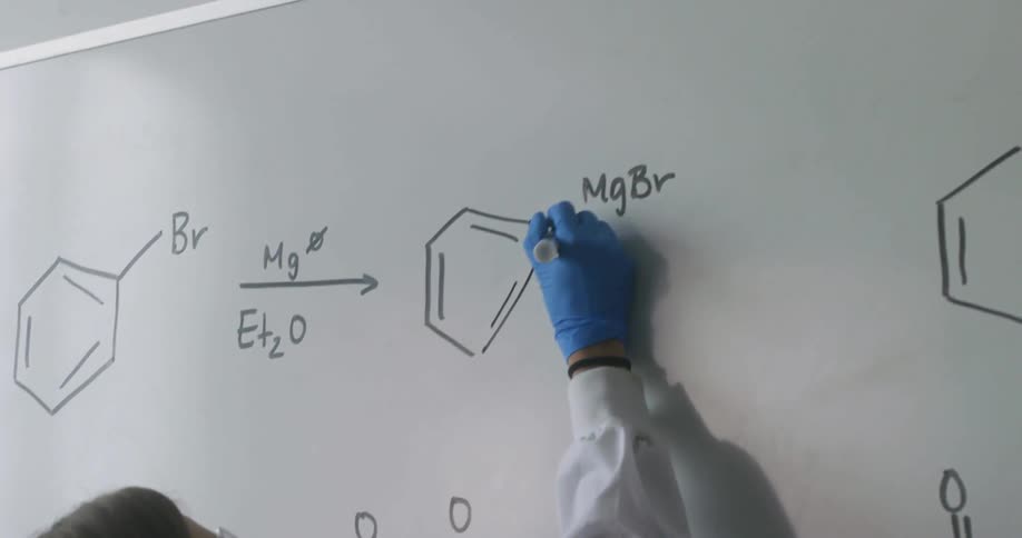 A young woman write equations on a white board