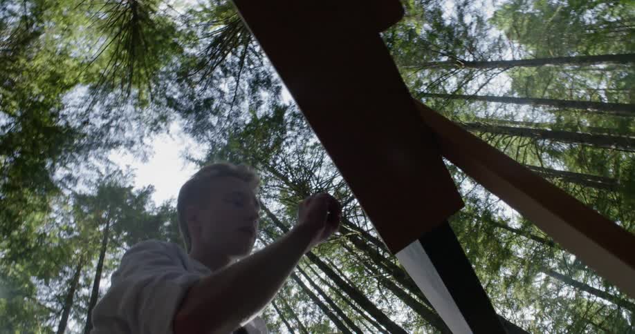 A man paints in the forest