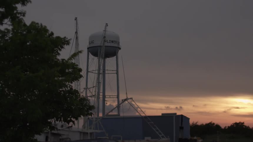 Passing by a water tower on a cloudy day near sunset
