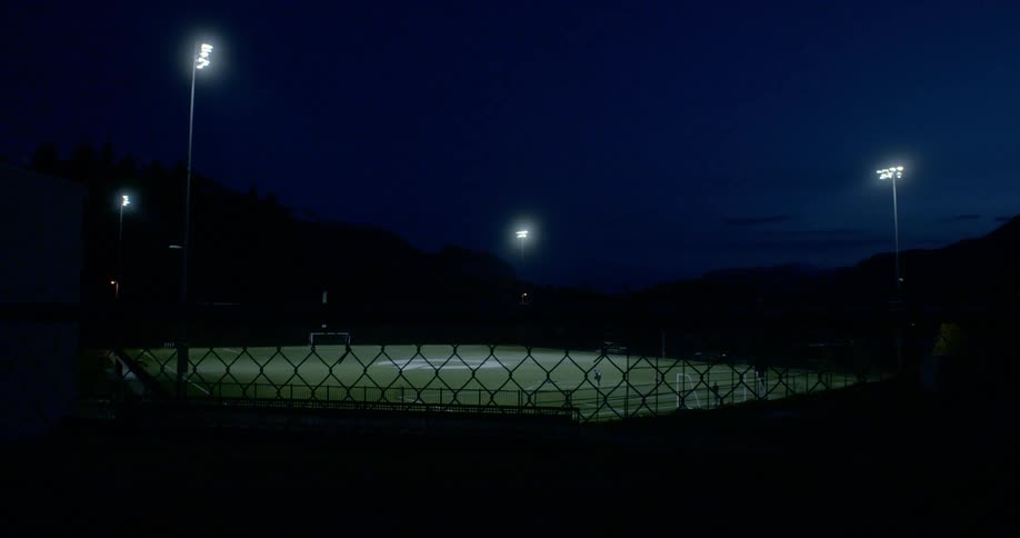 A soccer stadium lit up by lights at night