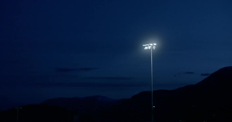 A light post is shining at night