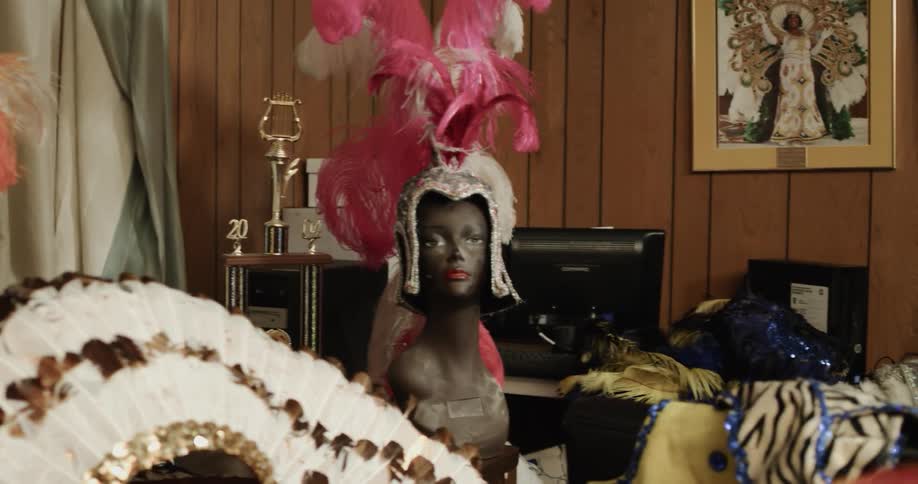 Elaborate feathered and stitched accessories strewn across a paneled room