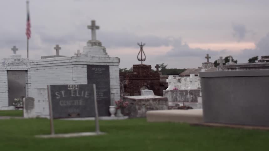 Headstones in a cemetery on a cloudy day