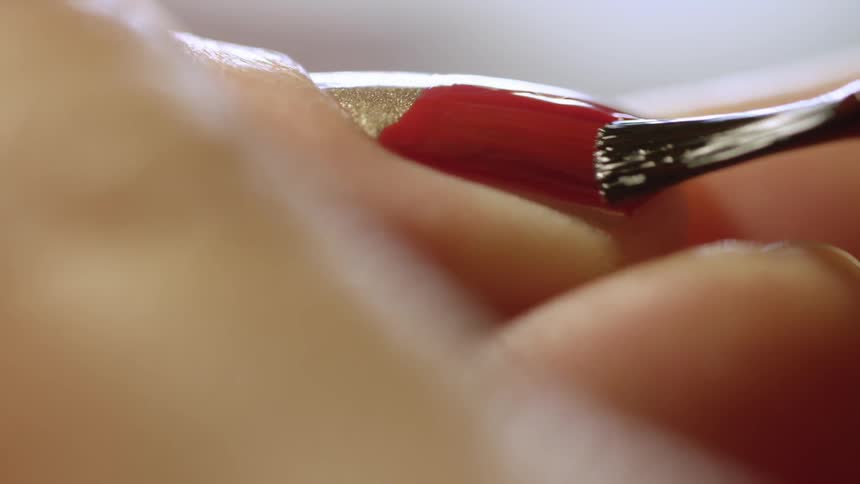 Woman painting her nails red