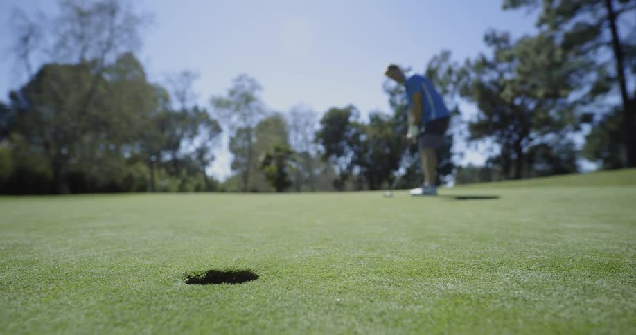 A man plays golf near the hole