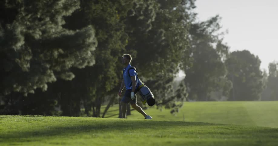 A man walks across a golf course