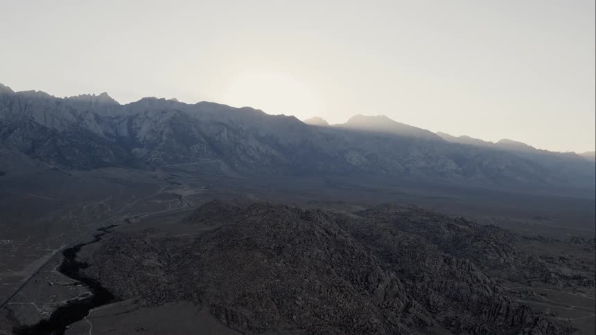 A river flows with mountains in the background