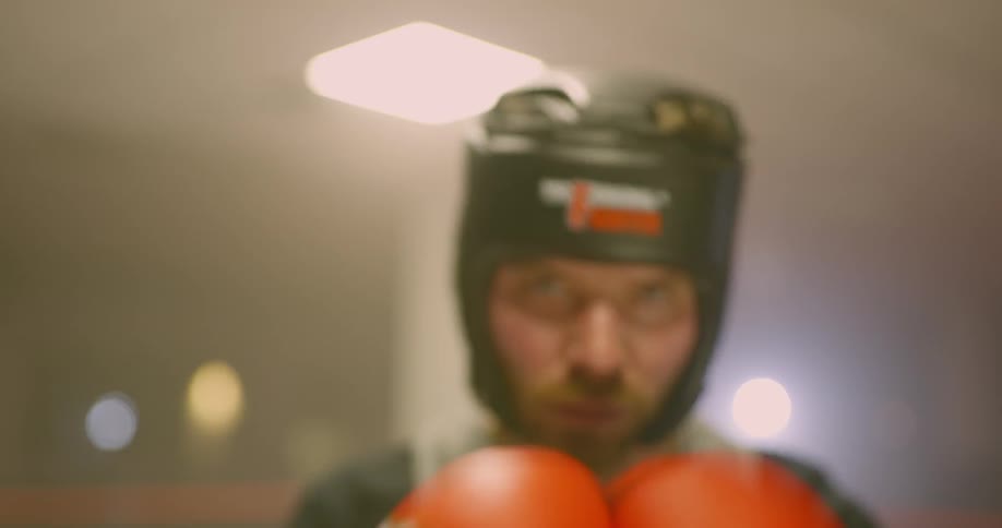 Boxer looks at the camera angrily and goes back to his corner to start fighting in the ring
