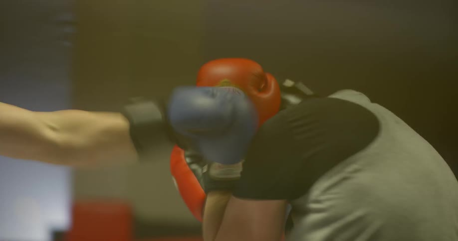 Boxers wearing protective head gear spar in the ring