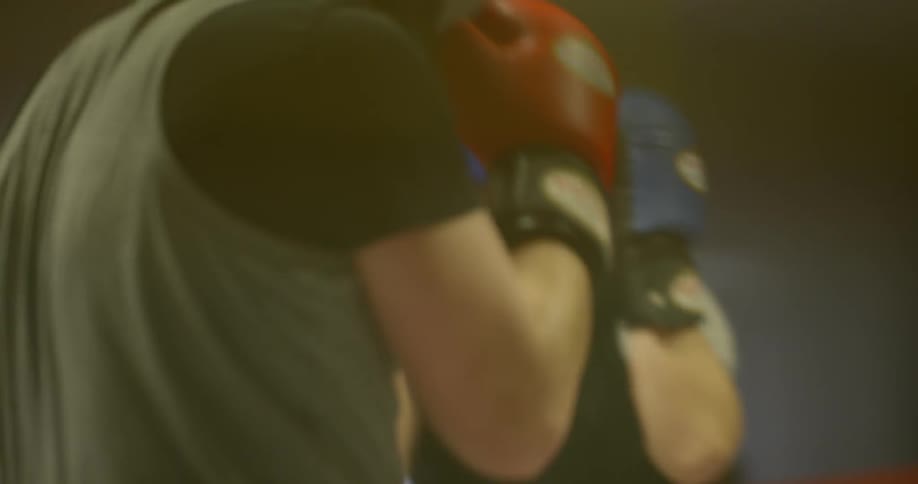 Two men spar in a boxing ring