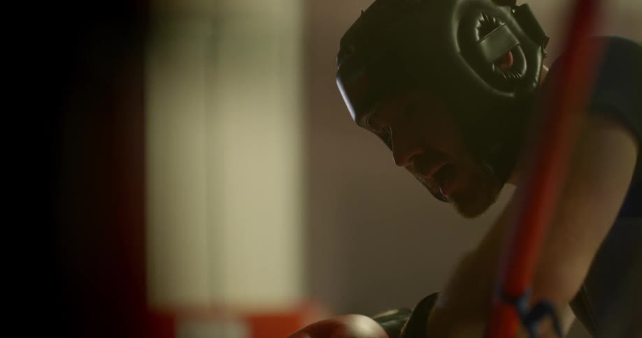 A boxer resting against the ropes