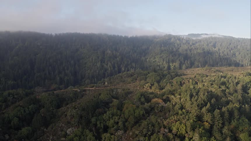 River and lake separate forest covered mountains
