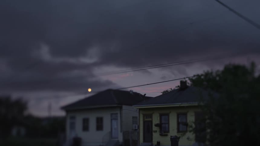 Storm clouds gathering over two yellow homes