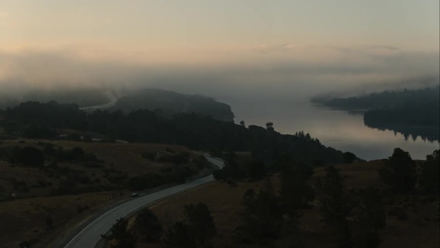 Car drive along a highway next to a lake