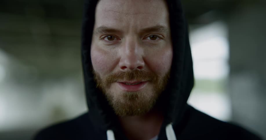 A man smirks into the camera