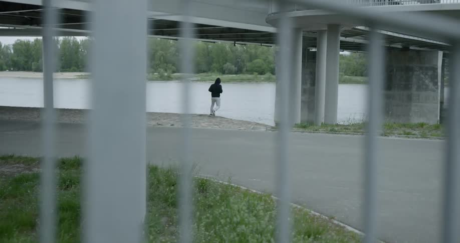 A person jogs off a path and towards a river