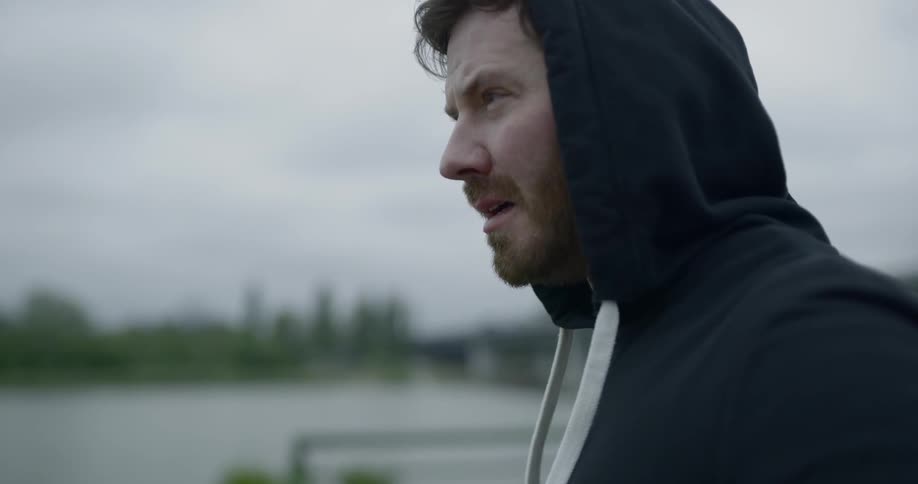 A man is standing outside on a cloudy day