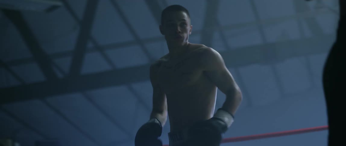 Two boxers spar in a boxing ring