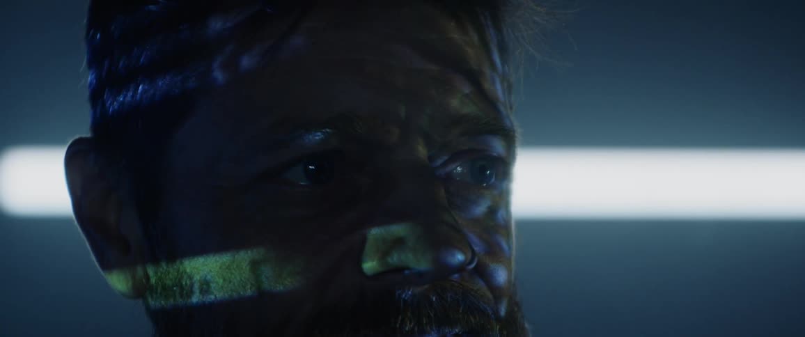 Lights and words are projected on a mans face
