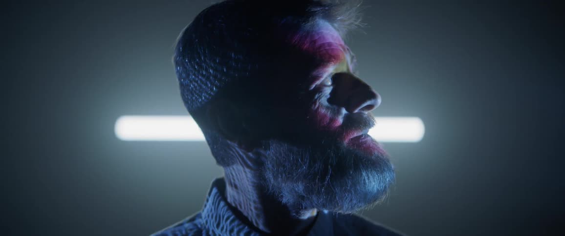 Close up side profile of older man with projection lighting on his face