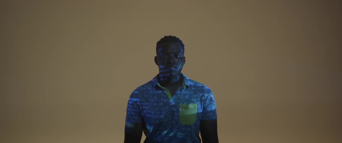 A man is covered in projected letters