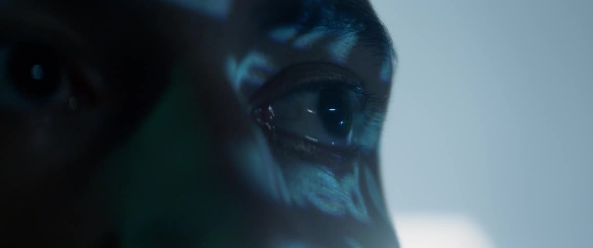 Close up of a persons face as lights reflect upon them
