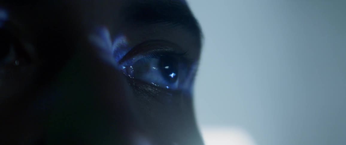 Close up of a teens eyes as he looks at a screen and lights flash